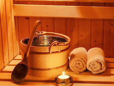 Sauna, benefici, sauna finlandese, sauna in legno, asciugamani, candele, cestino, legno, relax, benessere
